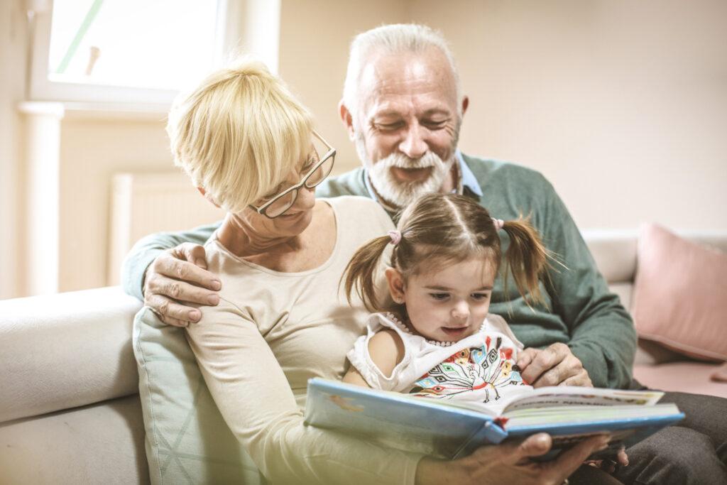 祖父母と孫が本を読んでいるイメージ